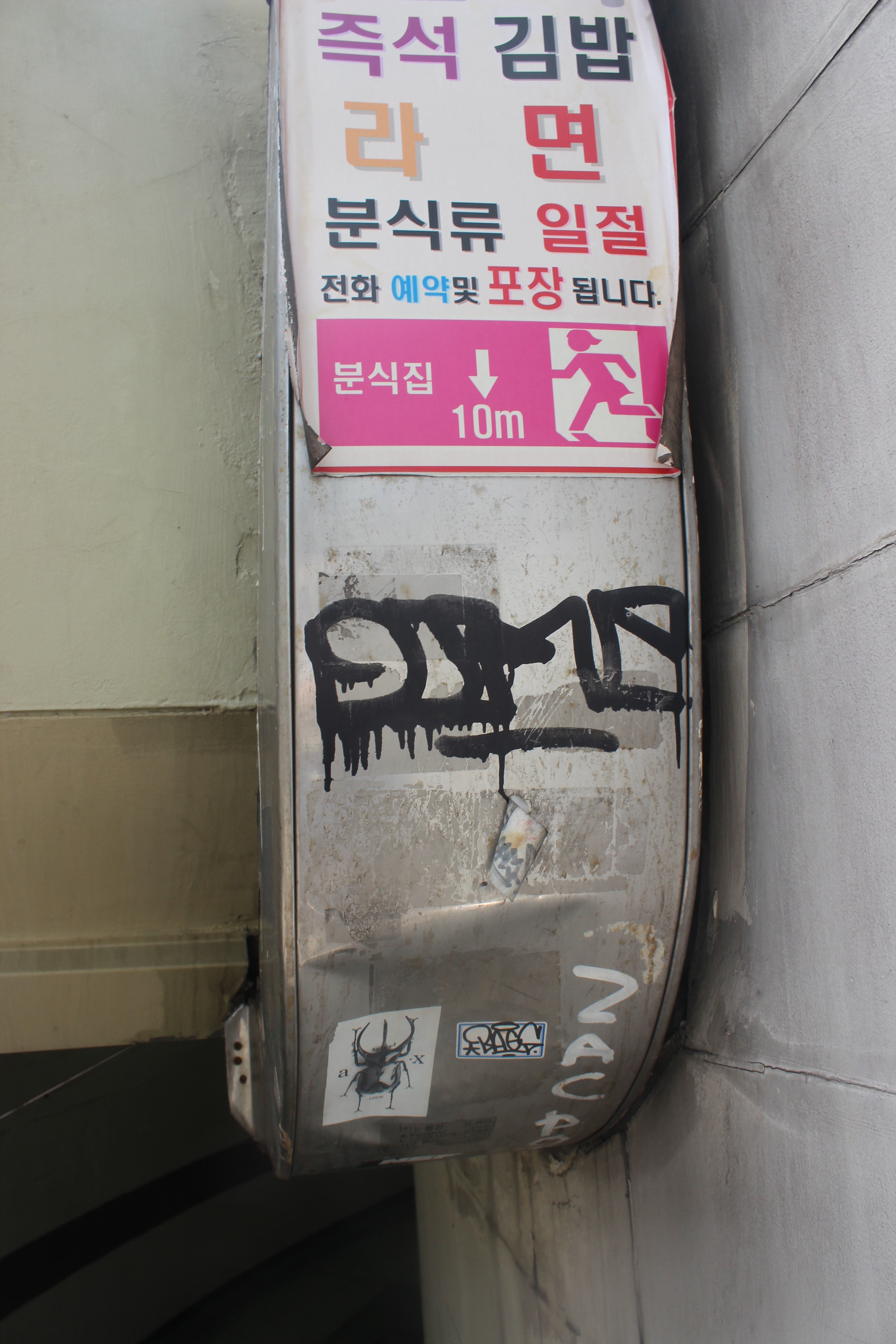 This strip of concrete above a subway entrance includes a compelling combination of commercial art, graffetti and advant garde art. 