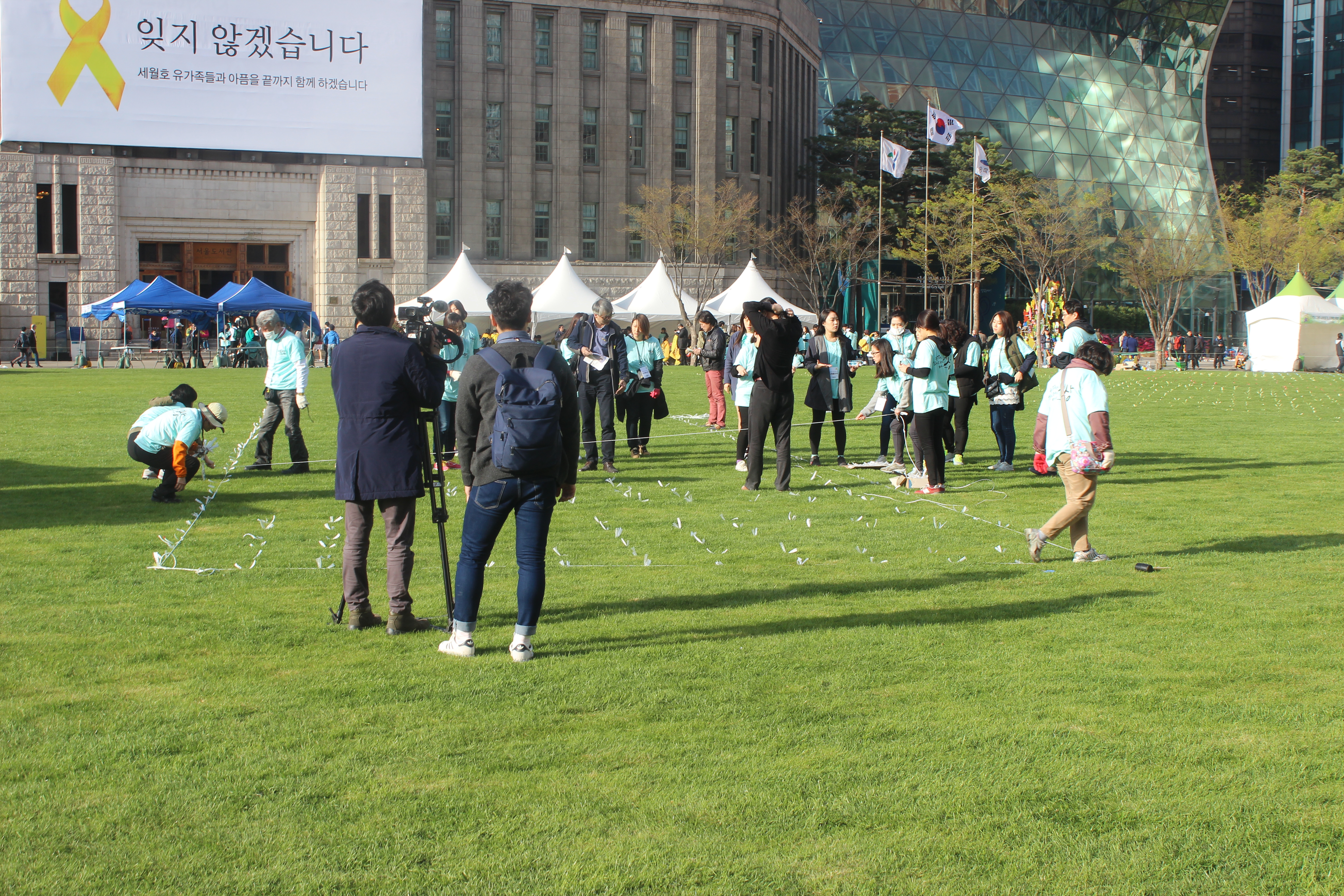 Laying down the strips that will mark where people sit with their candles for the vigil. 
